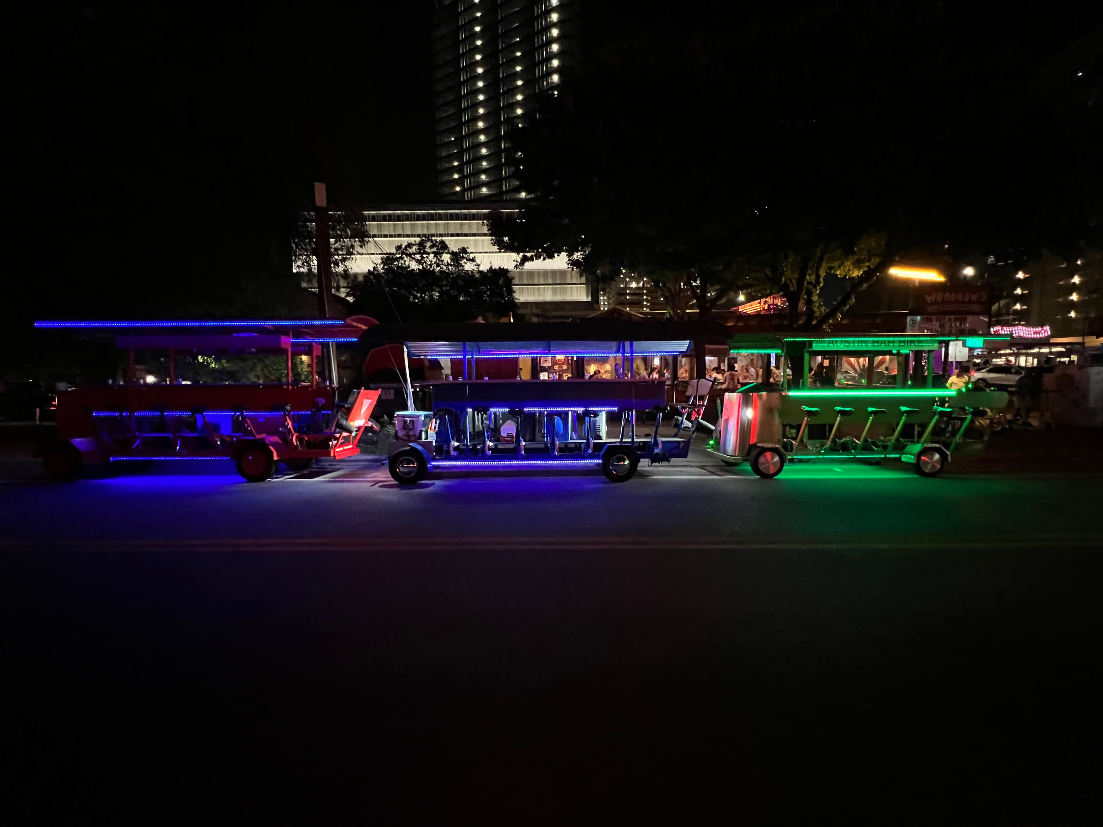 Austin Bar Bike fleet of BYOB party bikes lit up with LED lights on 6th Street at night
